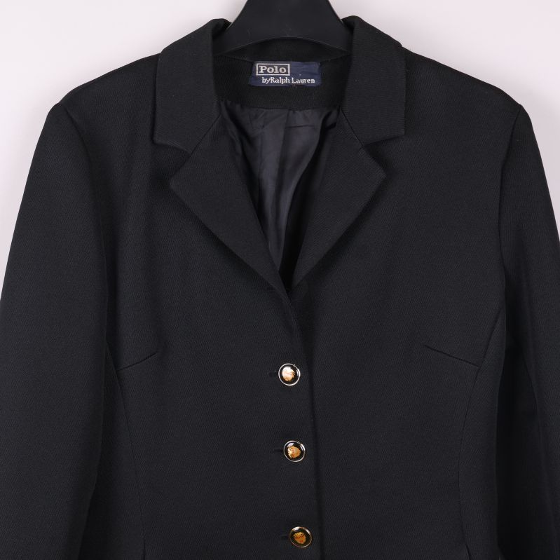 Övre delen av svart kavaj med tre knappar