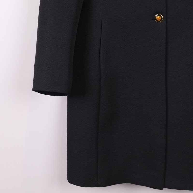 Ärmdetalj och nedre del av svart kavaj