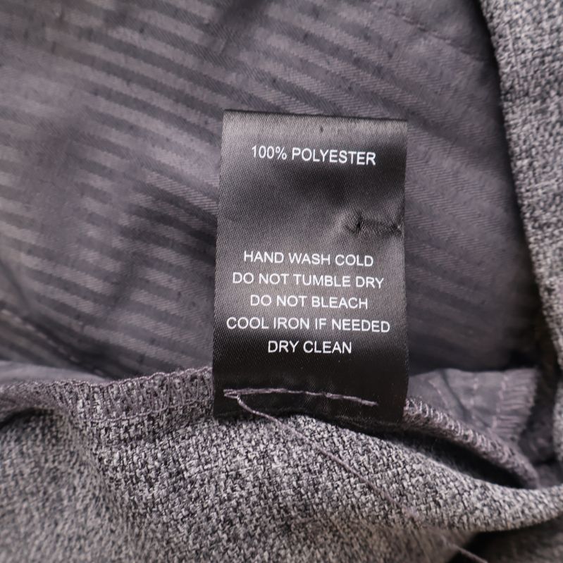 Materiallapp med texten 100% polyester och tvättråd