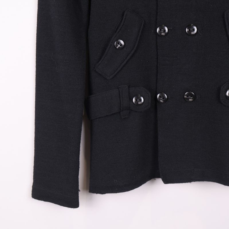 Nedre delen av svart kofta med fickor och bälte