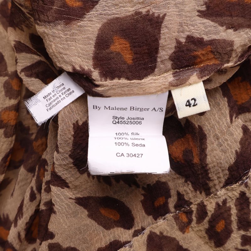 Tvättrådsetikett som visar 100% siden och storlek 42