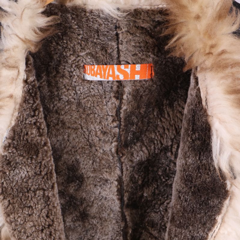 Närbild på orange etikett med märkesnamn i västen