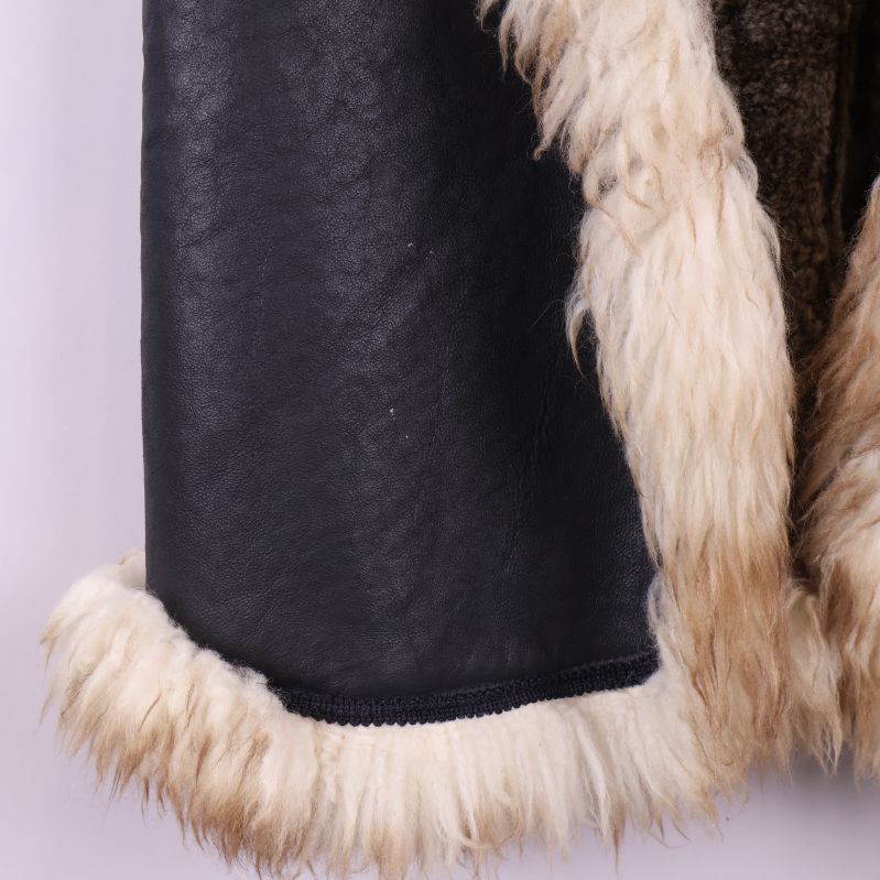 Detalj på västens svartbruna yta och ljus päls