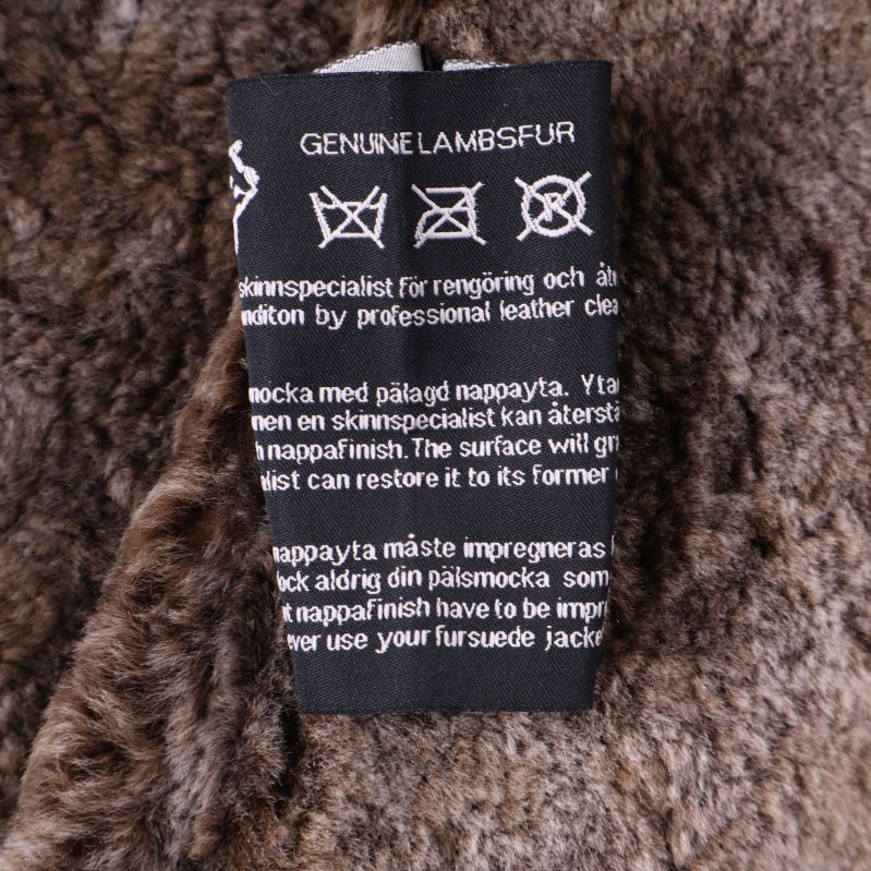 Materialetikett med information om äkta lammullspäls