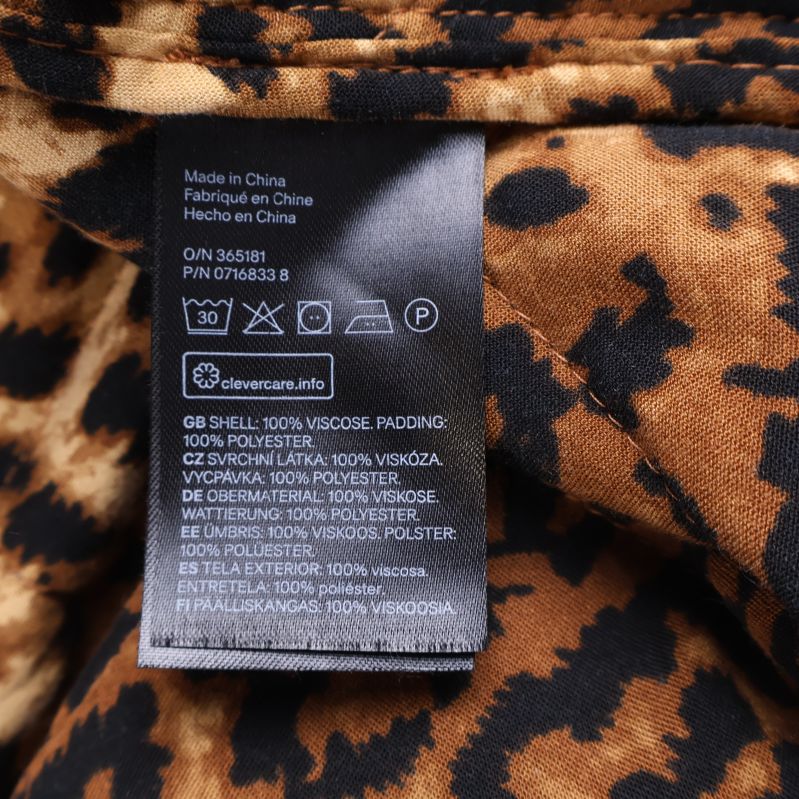 Materialetikett visar 100% viskos, vaddering 100% polyester