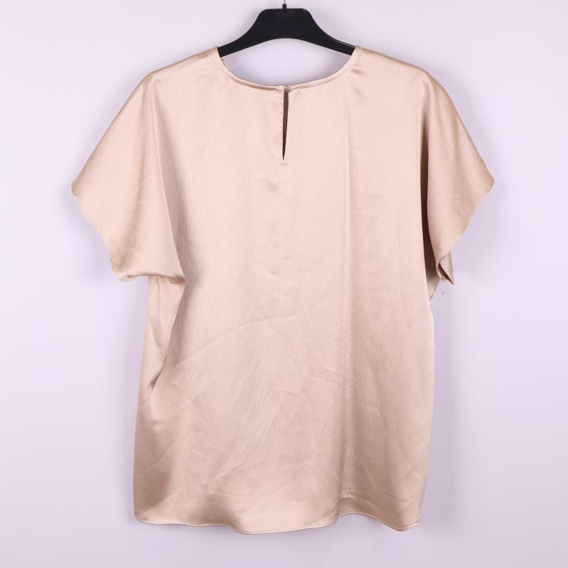 Baksida på beige strukturerad blus med kort ärm