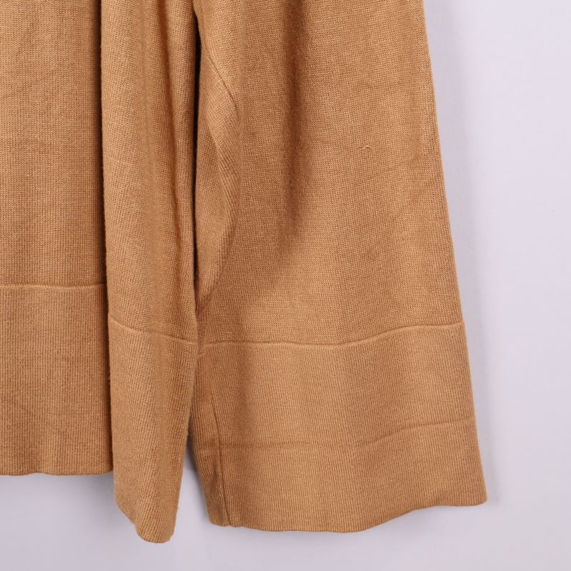 Närbild av utställd ärm på beige tröja
