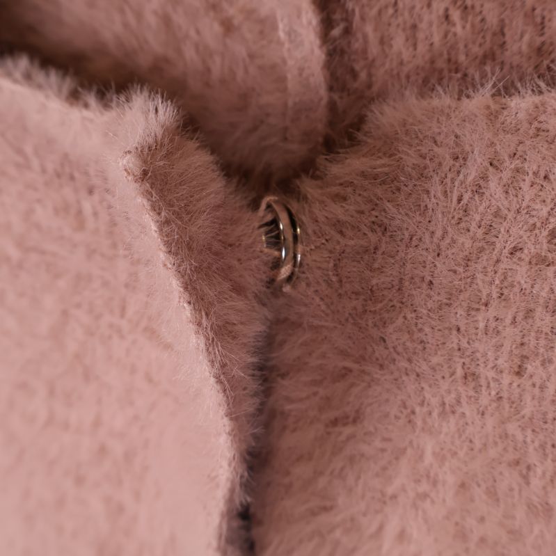 Närbild av knappstängning på teddycape