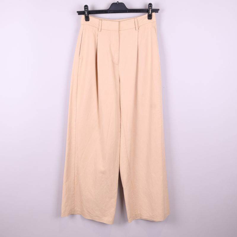 Framsida av vida beige byxor med hög midja