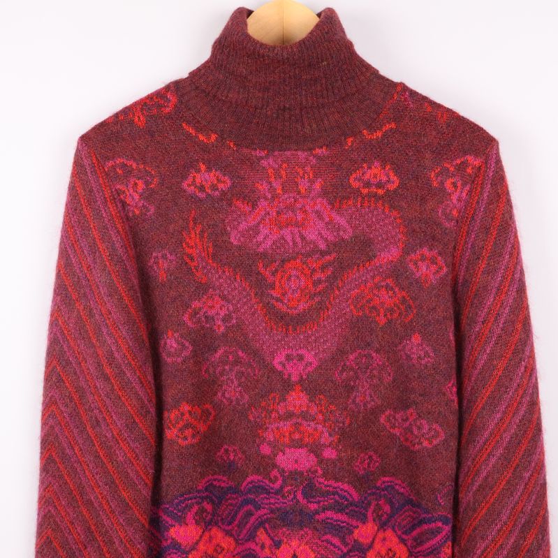 Närbild på polotröjans övre framstycke med drakmönster