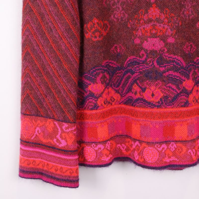 Närbild på ärm och nederkant med färgrika mönsterdetaljer