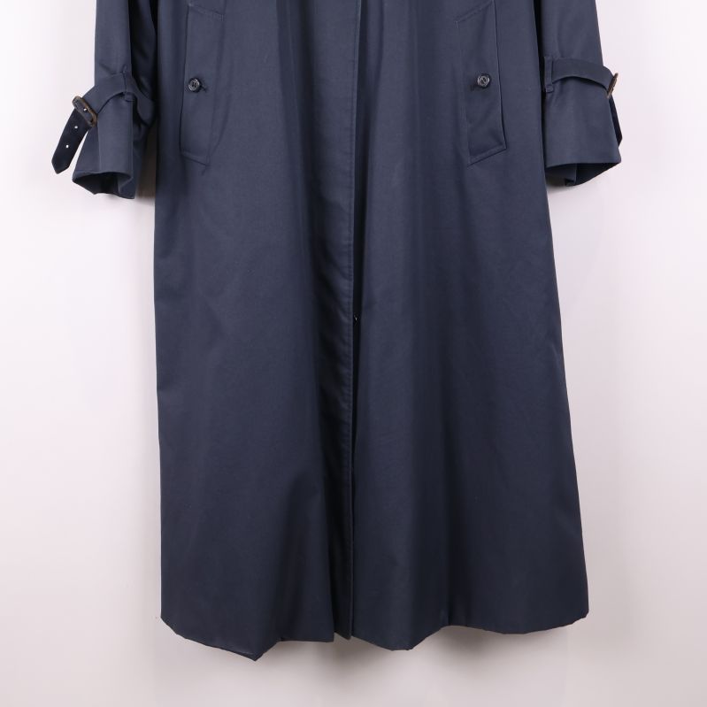 Närbild på nederdelen av mörkblå trenchcoat