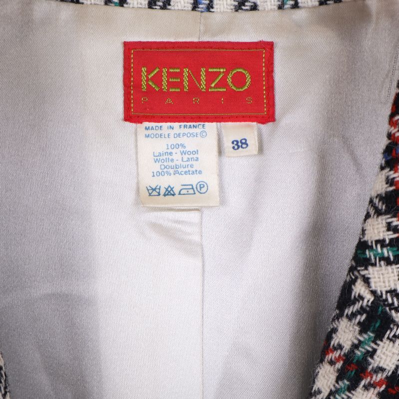 Närbild på Kenzo-märke och materialetikett i kavajen