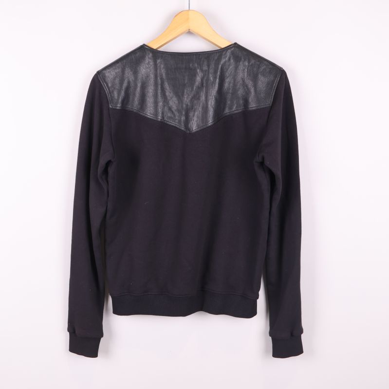 Svart sweatshirt med läderparti över axlarna sedd bakifrån