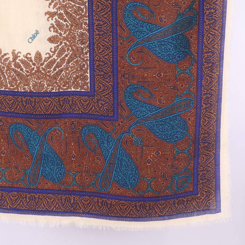 Närbild av sjalens blå paisleymönster och bruna kant