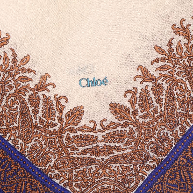 Närbild på broderad Chloé-logo och bruna mönster