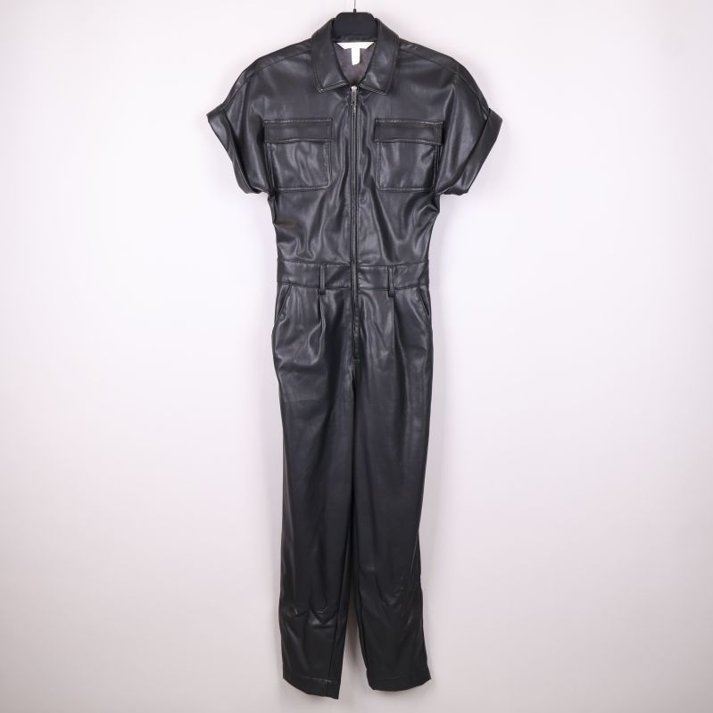 Svart jumpsuit i konstläder upphängd hel frontal vy