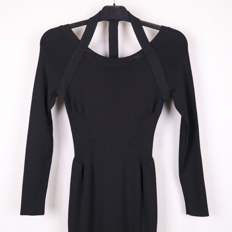 Närbild på överdelen av svart klänning med band vid halsen