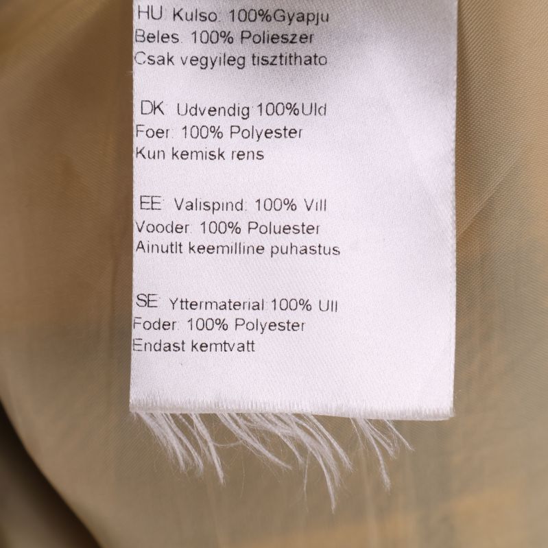 Materiallapp som visar 100 procent ull och polyesterfoder