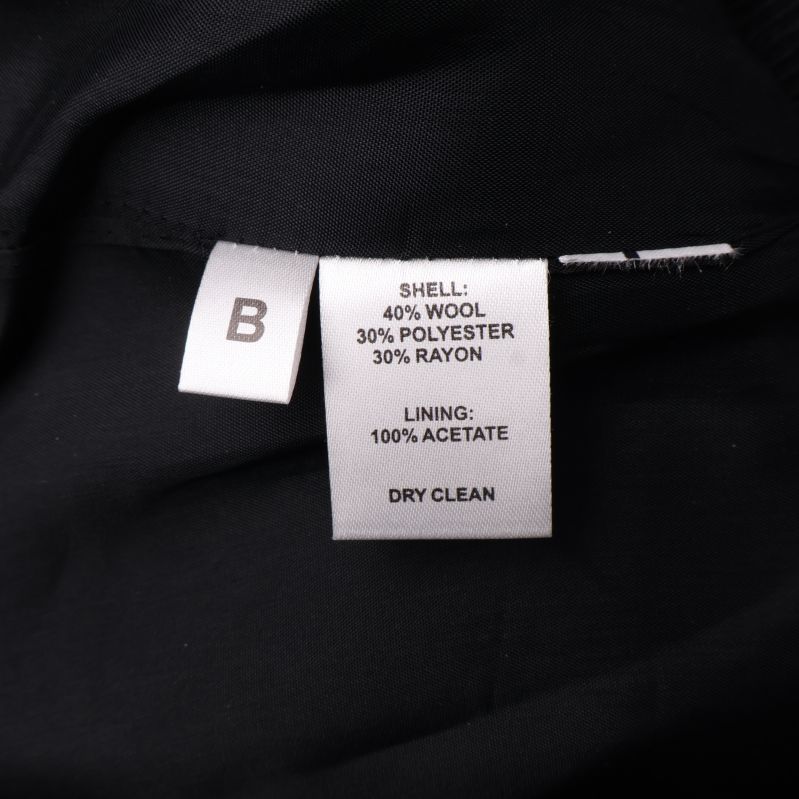 Materialetikett med information om ull, polyester, rayon och acetat