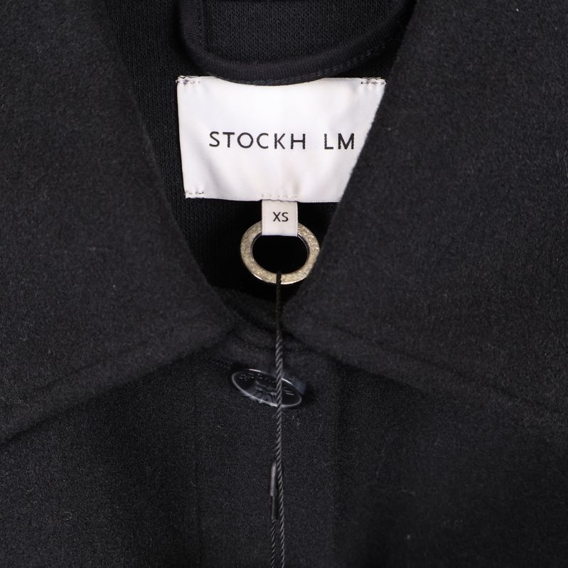Närbild på krage och varumärkesetikett STOCKH LM