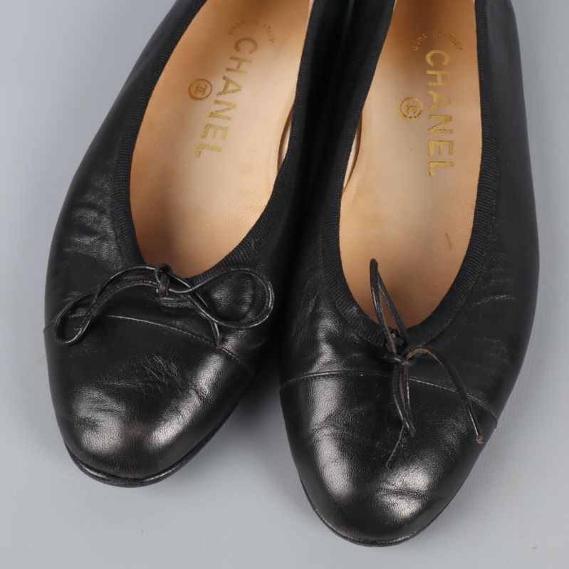 Närbild på tårna och rosetterna på svarta ballerina