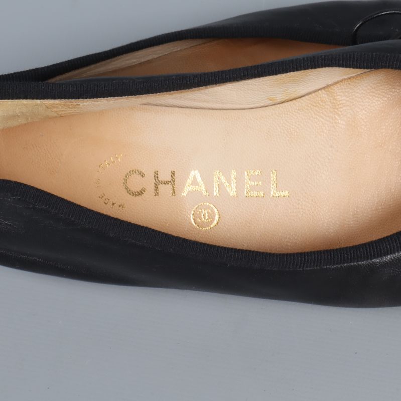 Närbild på guldfärgad Chanel-logotyp på innersulan