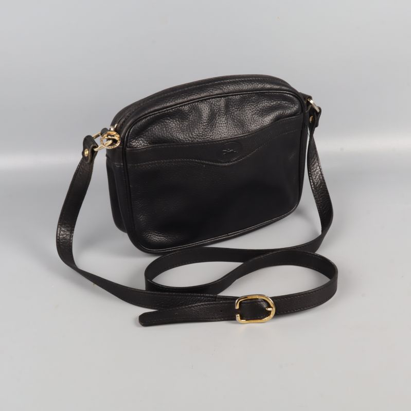 Axelväska i svart läder med justerbar rem och gulddetaljer