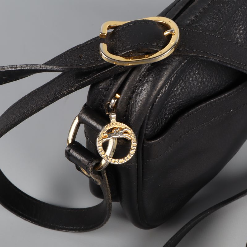 Närbild på guldfärgat spänne och dragkedja till väska