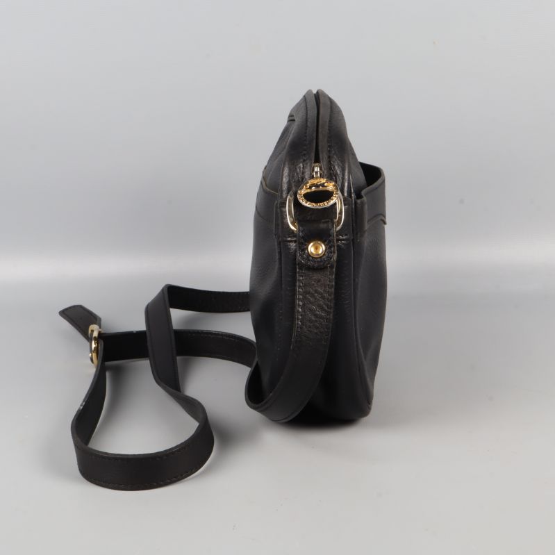 Svart axelväska sedd från sidan med justerbar rem