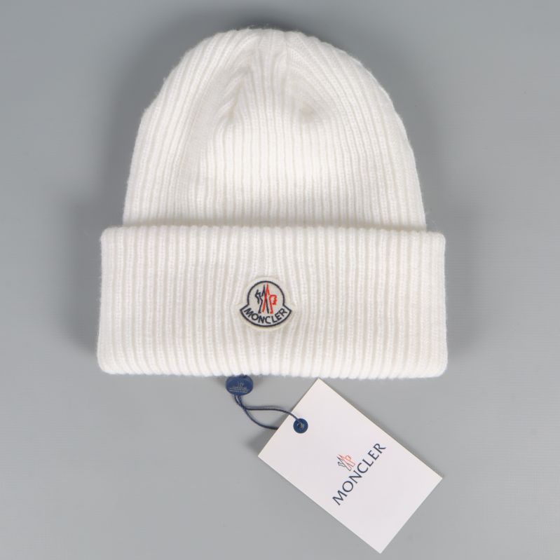 Mössa i ribbstickning med vikt kant och hängande namntag