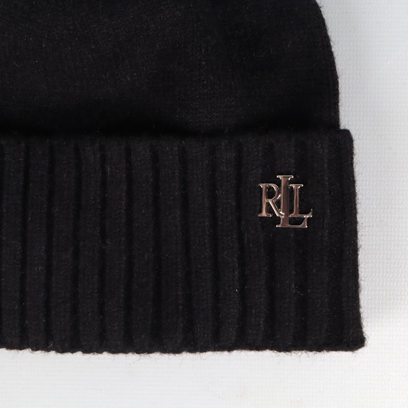 Närbild på mössans metallmonogram RL på kanten