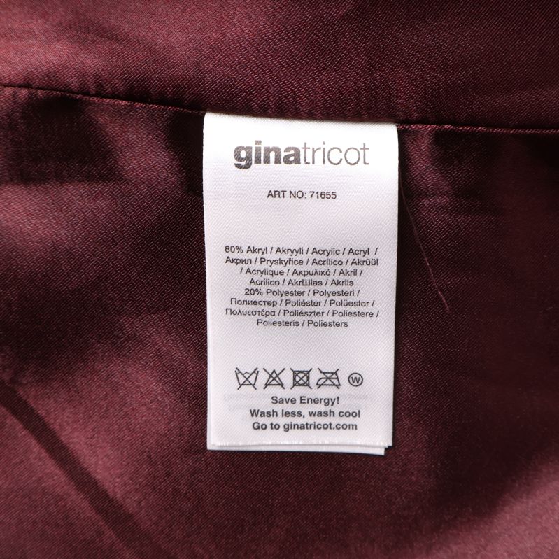 Materialetikett för väst från Gina Tricot i vinrött tyg