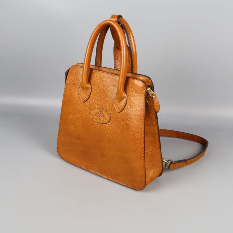 Ryggsäckväska i brunt präglat läder med handtag och axelremmar