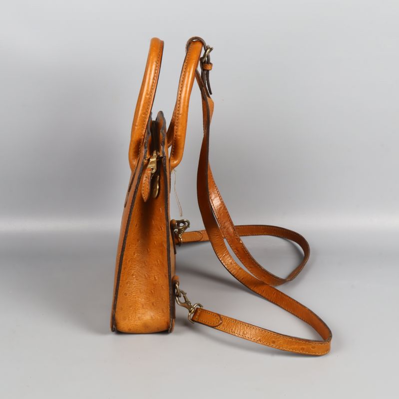 Sidan av brun väska med smal profil och axelrem
