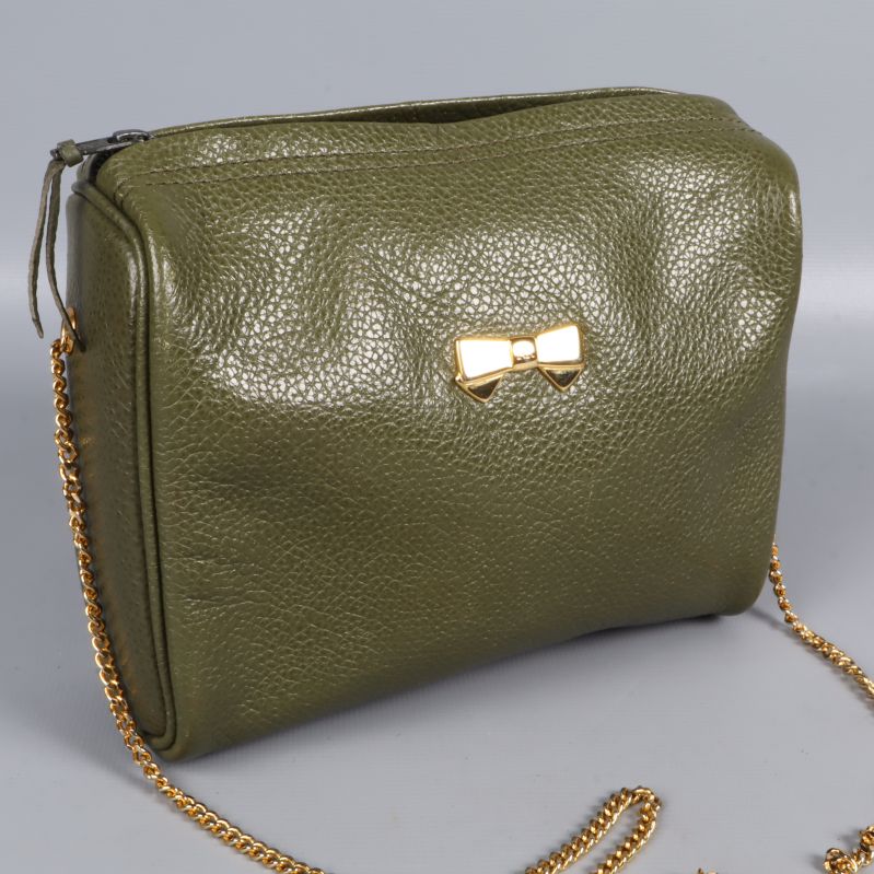 Närbild på grön väska med rosett och struktur