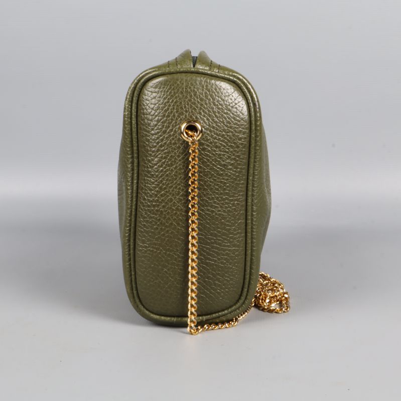 Sidovy av grön väska med guldkedja