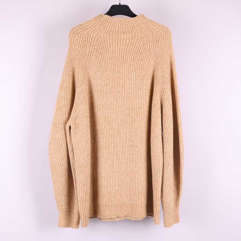 Baksida på beige stickad tröja 