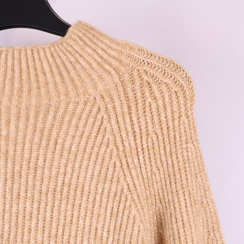 Närbild på axel och hals på stickad tröja