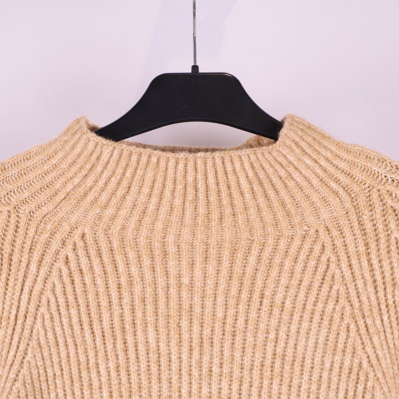 Närbild på halsringning av stickad tröja