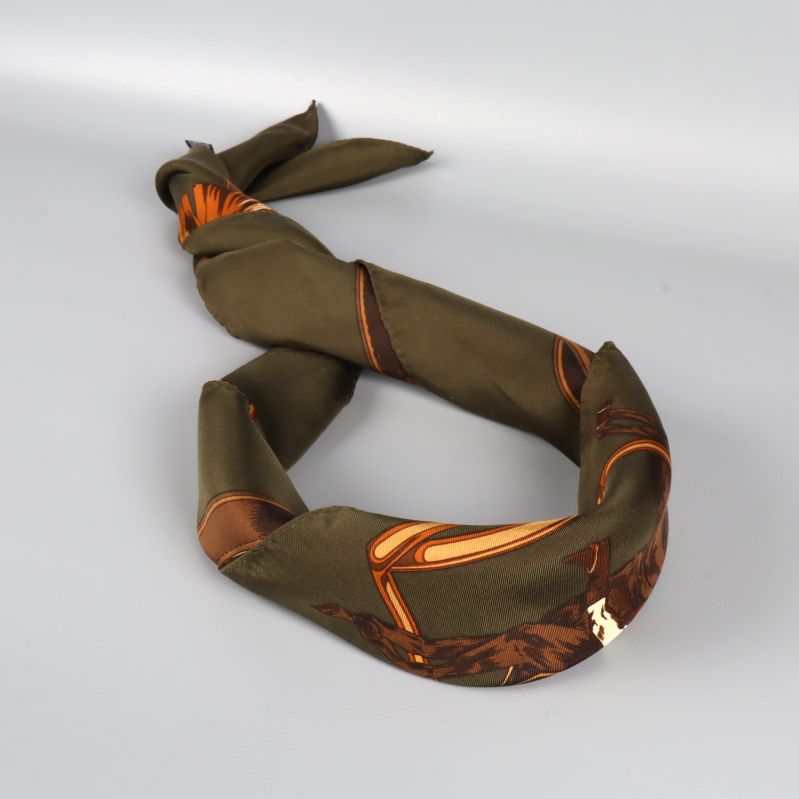 Grön scarf tvinnad till ett band med motiv