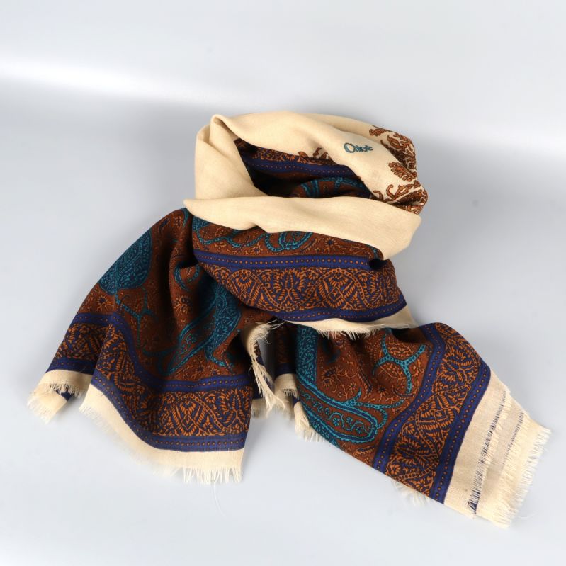 Sjal i creme och brunt ihoprullad som halsduk