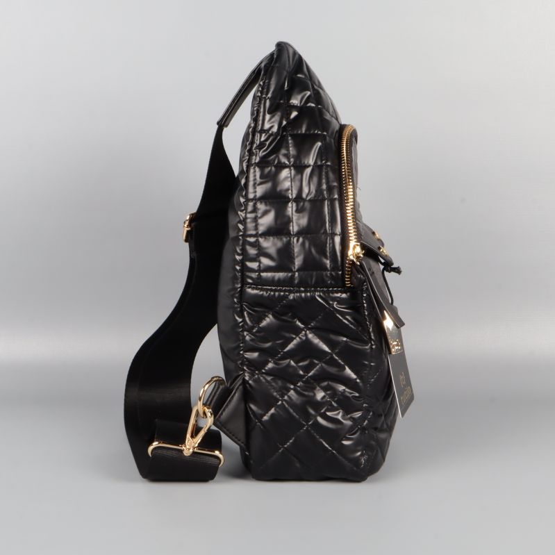 Sidovy av svart quiltad crossbody-väska med bred rem