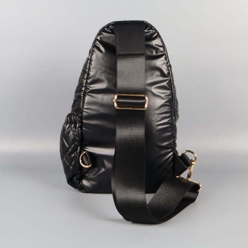 Baksidan av svart quiltad crossbody-väska med axelrem i textil