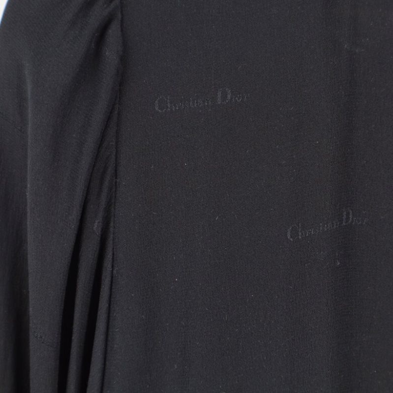 Närbild på subtilt Christian Dior-logomönster på svart tyg