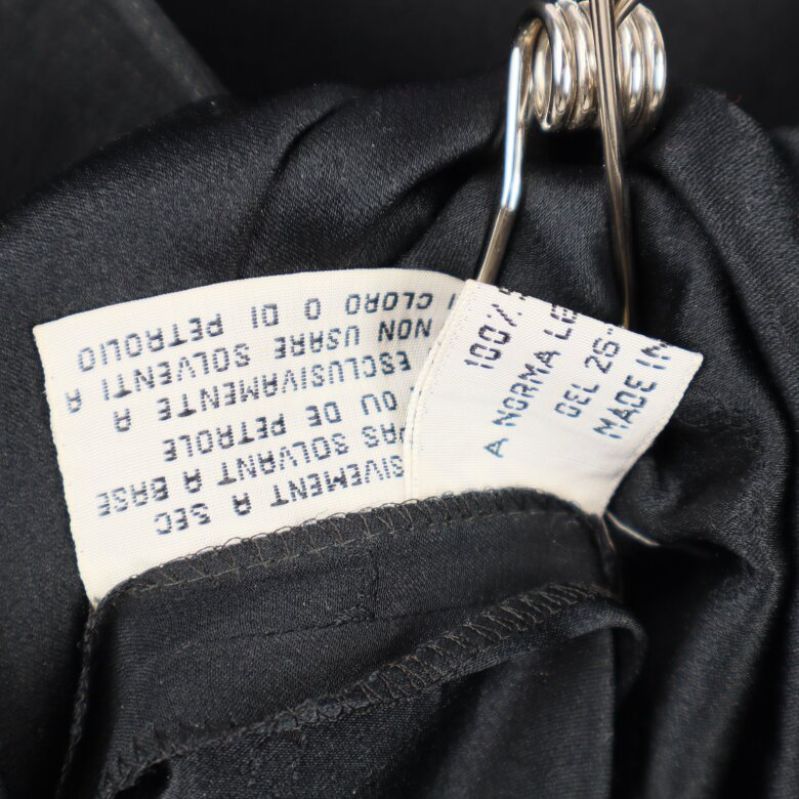 Textiletikett i svart klänning synlig i närbild