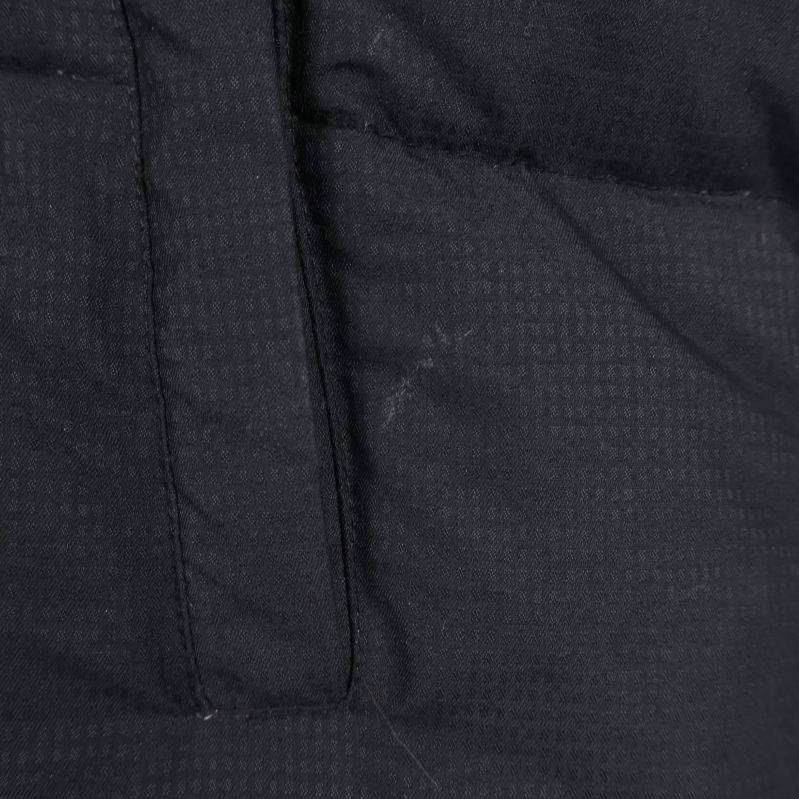 Detaljfoto på fläck intill vänster ficka på västen