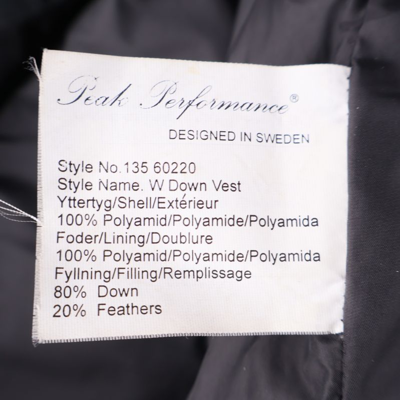 Materialetikett visar polyamid yttertyg och dunfyllning i Peak Performance väst