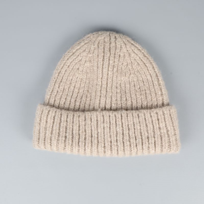 Ribbstickad beige mössa med bred kant framifrån