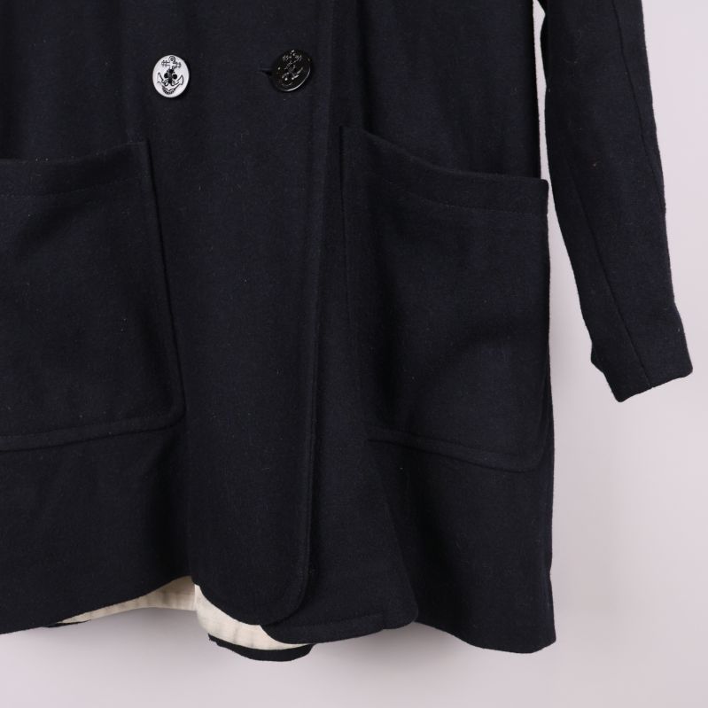 Nedre höger ficka och knappdetaljer på kappan